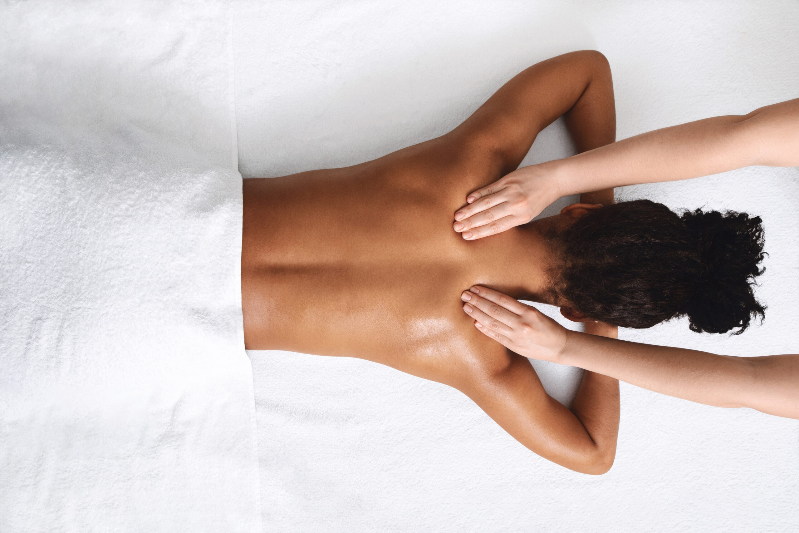 Neck massage for black lady lying down, view above